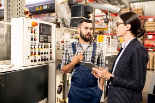 coworkers in warehouse discussing it services for manufacturing companies