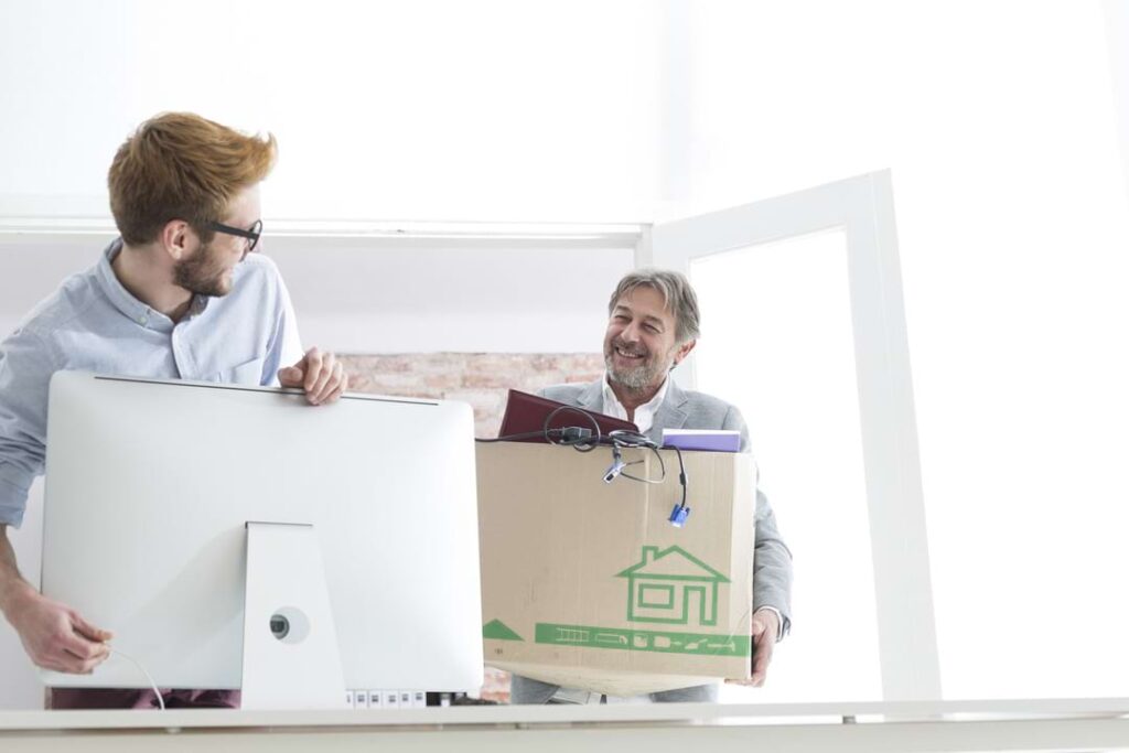 Two men moving boxes for an office IT relocation