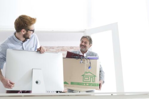 Two men moving boxes for an office IT relocation